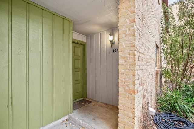 entrance to property with board and batten siding and brick siding