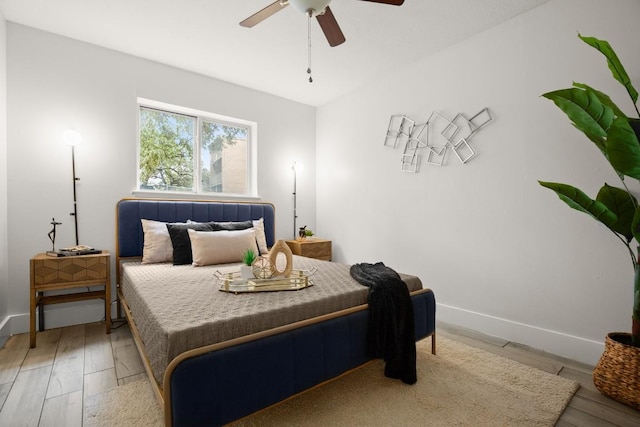 bedroom with a ceiling fan, baseboards, and wood finished floors