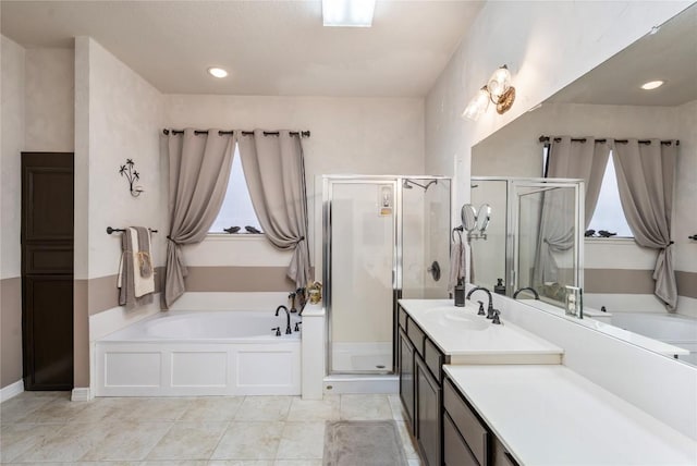 bathroom featuring a stall shower, a garden tub, and vanity