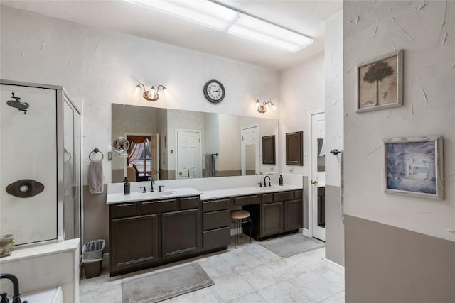 bathroom featuring marble finish floor, a sink, a shower stall, and double vanity