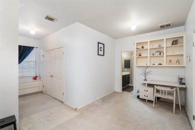 office featuring baseboards, visible vents, and light colored carpet