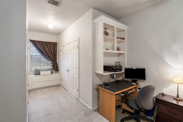 office area featuring a textured ceiling, a textured wall, light colored carpet, visible vents, and baseboards