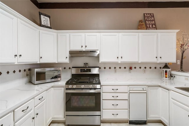 kitchen with light stone counters, tasteful backsplash, appliances with stainless steel finishes, white cabinetry, and under cabinet range hood