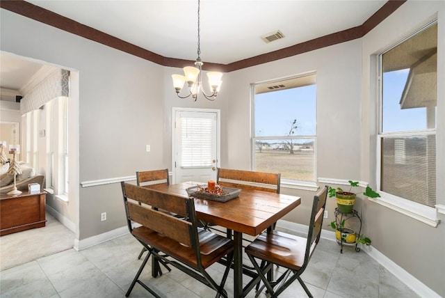 dining area with baseboards, visible vents, and a notable chandelier