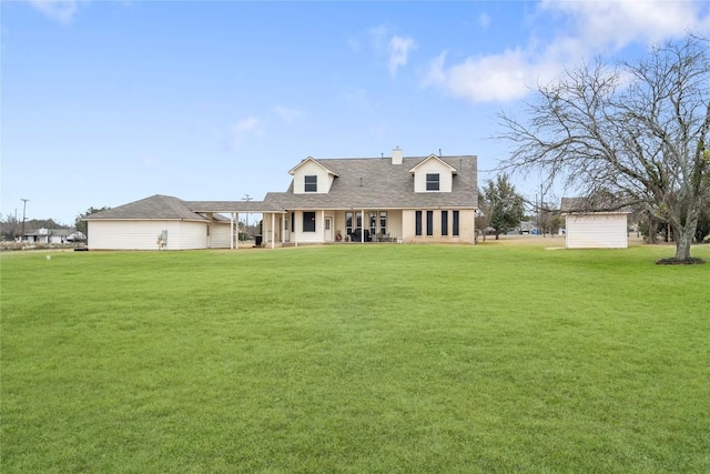 back of house featuring a storage shed, a lawn, and an outbuilding