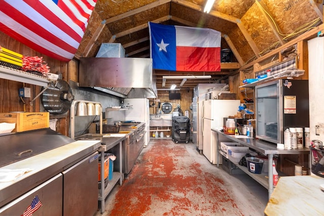 kitchen featuring unfinished concrete floors and freestanding refrigerator
