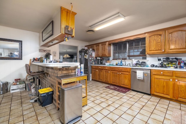kitchen with brown cabinetry, light countertops, and stainless steel appliances