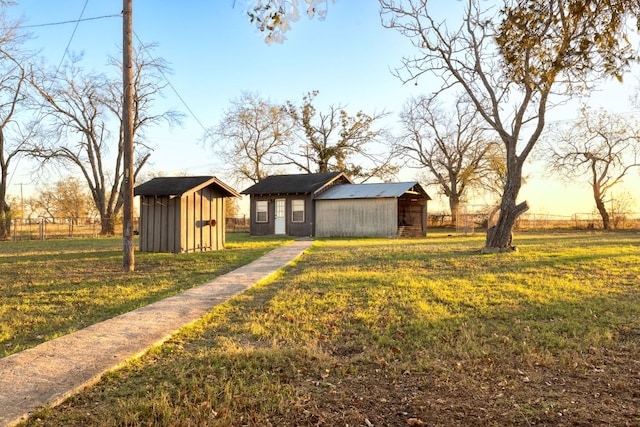 view of yard with an outbuilding, fence, and a pole building