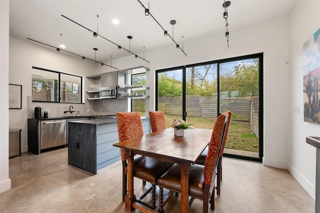 dining space with finished concrete floors and baseboards