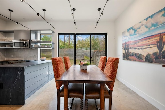 dining space featuring concrete floors and baseboards