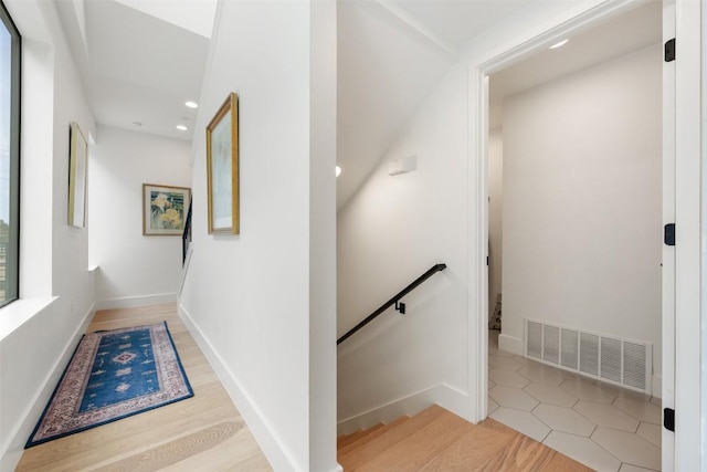 staircase featuring baseboards, visible vents, wood finished floors, and recessed lighting