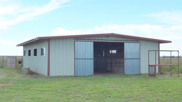 view of pole building with fence and a yard