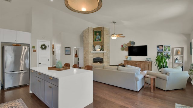 kitchen featuring light countertops, freestanding refrigerator, open floor plan, and white cabinets