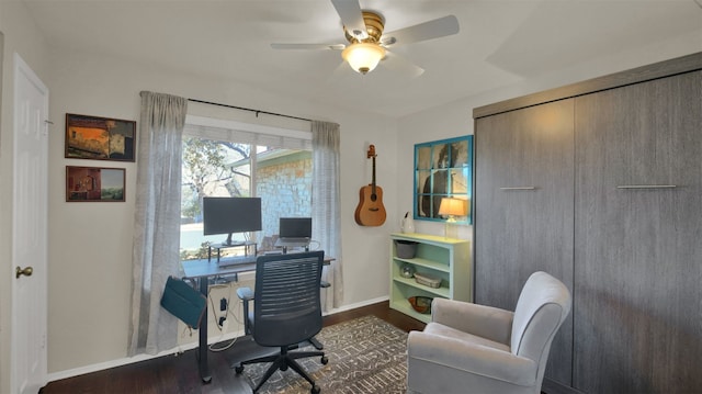 office area with dark wood finished floors, baseboards, and ceiling fan