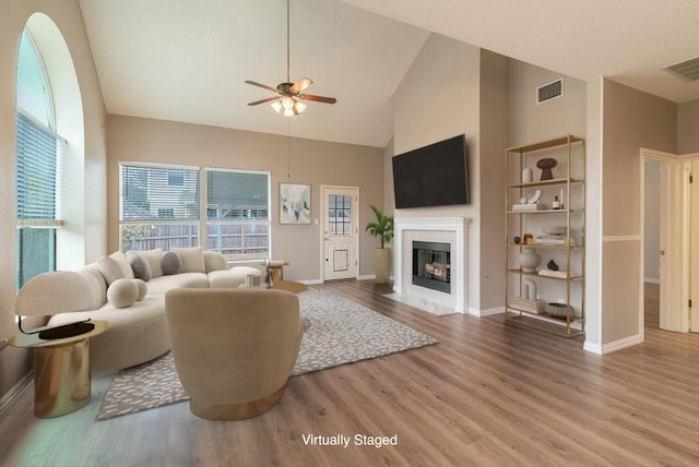 8507 Chat Ln, Round Rock, TX 78681 - living room with high vaulted ceiling, a fireplace, ceiling fan, and wood finished floors