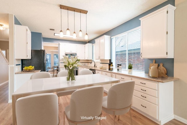 8507 Chat Ln, Round Rock, TX 78681 - kitchen featuring stainless steel appliances, light wood-style floors, white cabinets, and light countertops