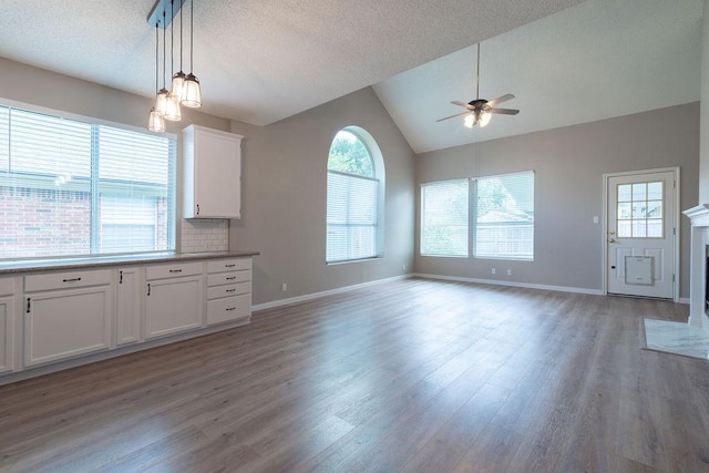 8507 Chat Ln, Round Rock, TX 78681 - kitchen featuring a ceiling fan, open floor plan, light wood-type flooring, vaulted ceiling, and white cabinets