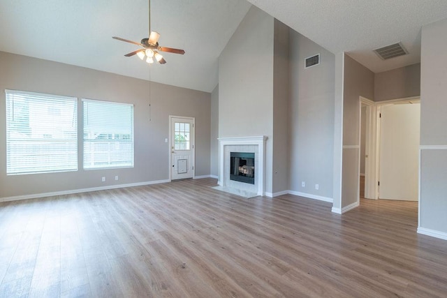8507 Chat Ln, Round Rock, TX 78681 - unfurnished living room with a ceiling fan, high vaulted ceiling, light wood-style floors, and a fireplace with flush hearth