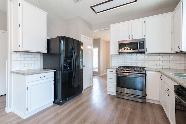 8507 Chat Ln, Round Rock, TX 78681 - kitchen featuring black appliances, light wood finished floors, white cabinetry, tasteful backsplash, and light stone countertops