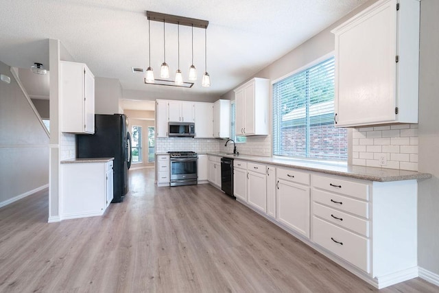 8507 Chat Ln, Round Rock, TX 78681 - kitchen with black appliances, light wood-style flooring, and tasteful backsplash
