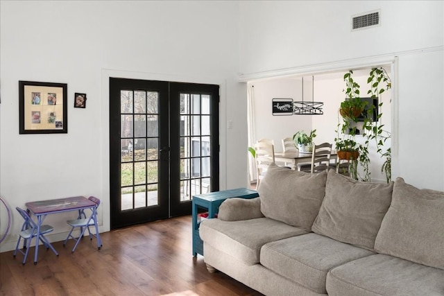 living room with dark wood-style floors, french doors, visible vents, and a healthy amount of sunlight