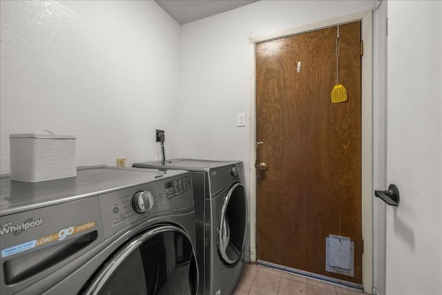 laundry room featuring light tile patterned floors, laundry area, and washer and clothes dryer