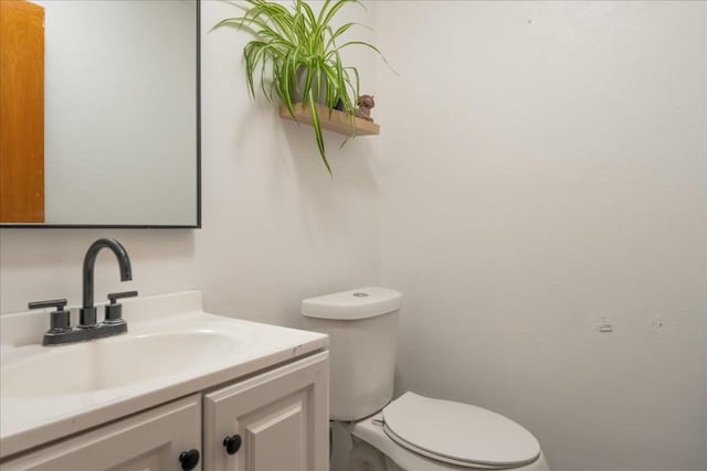 half bathroom with toilet and vanity