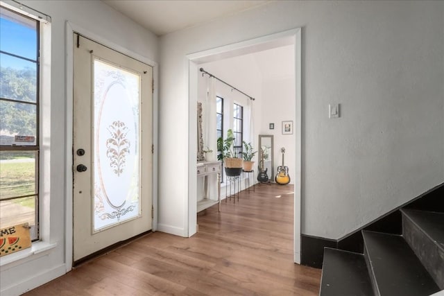 foyer entrance with light wood-style flooring and baseboards