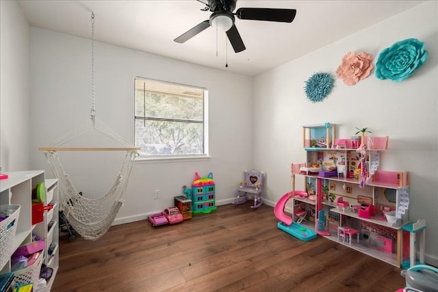 rec room with dark wood-style floors, ceiling fan, and baseboards