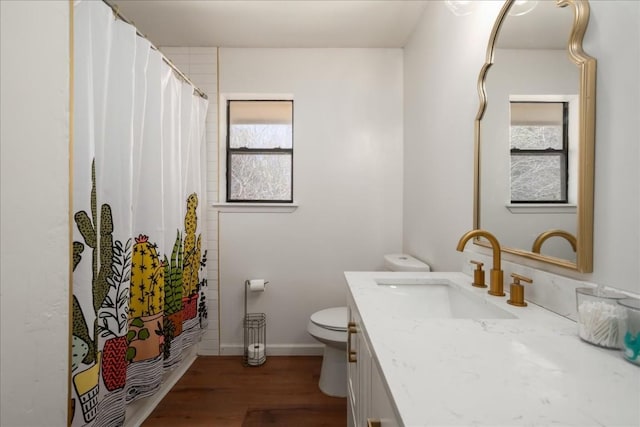 full bath featuring toilet, wood finished floors, vanity, and baseboards