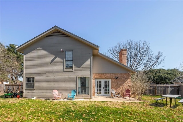 rear view of house featuring a patio, a yard, fence, and brick siding