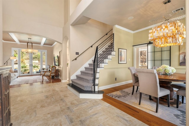 dining space featuring baseboards, stairs, arched walkways, and french doors