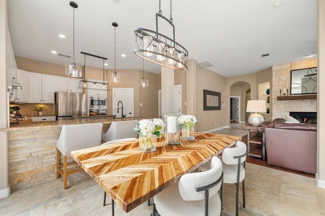 dining area featuring arched walkways, visible vents, baseboards, and recessed lighting