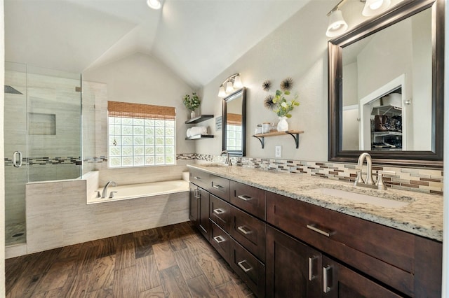 bathroom featuring lofted ceiling, a sink, a bath, and a shower stall