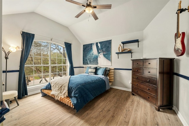 bedroom featuring vaulted ceiling, ceiling fan, light wood-style flooring, and baseboards