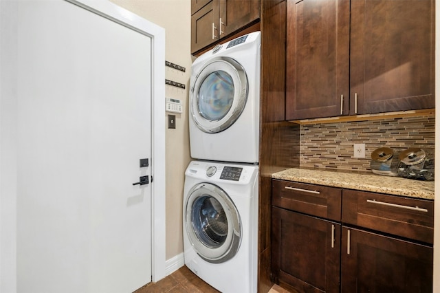 laundry area with cabinet space and stacked washer and clothes dryer