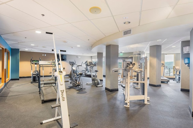 exercise room featuring baseboards, visible vents, and a drop ceiling