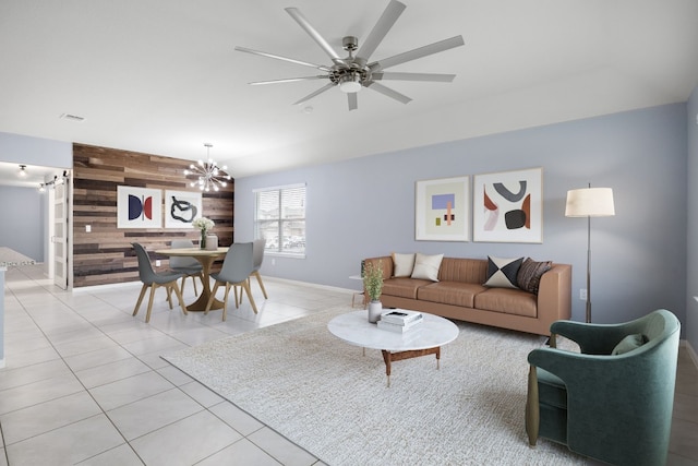 living room featuring an accent wall, ceiling fan with notable chandelier, wooden walls, and light tile patterned floors