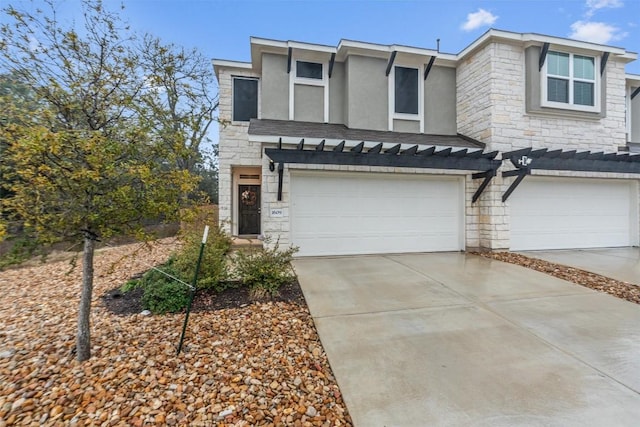 multi unit property with stone siding, concrete driveway, an attached garage, and stucco siding