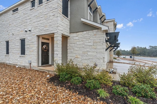 entrance to property with stone siding and stucco siding