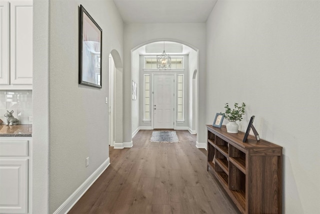 1820 Ficuzza Way, Leander, TX 78641 - foyer entrance featuring arched walkways, wood finished floors, baseboards, and a chandelier