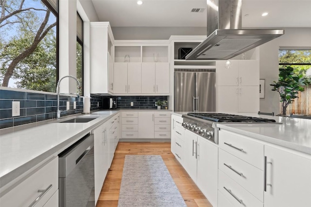 4907 Timberline Dr, Austin, TX 78746 - kitchen with appliances with stainless steel finishes, a sink, island exhaust hood, tasteful backsplash, and recessed lighting