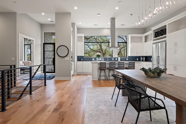 4907 Timberline Dr, Austin, TX 78746 - kitchen featuring built in refrigerator, backsplash, light wood-style flooring, white cabinetry, and recessed lighting