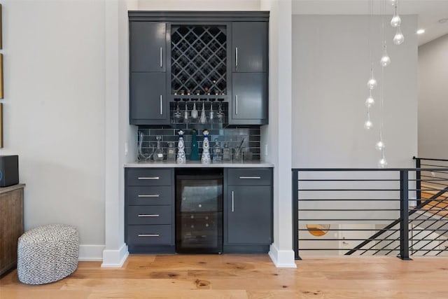 4907 Timberline Dr, Austin, TX 78746 - indoor bar featuring beverage cooler, baseboards, light wood-style floors, decorative backsplash, and pendant lighting