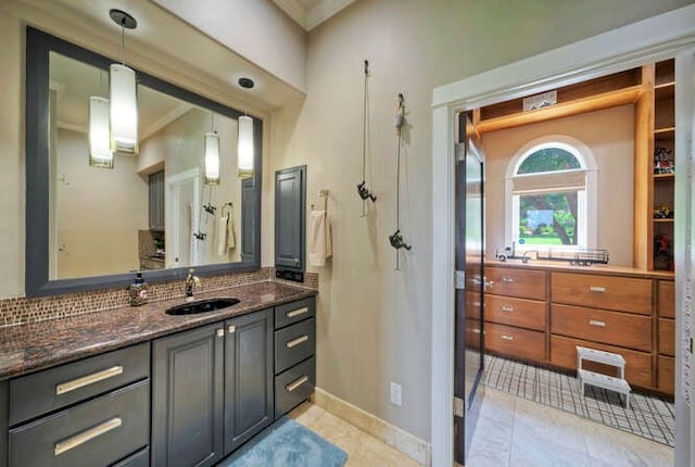 full bath featuring tasteful backsplash, tile patterned flooring, vanity, and baseboards