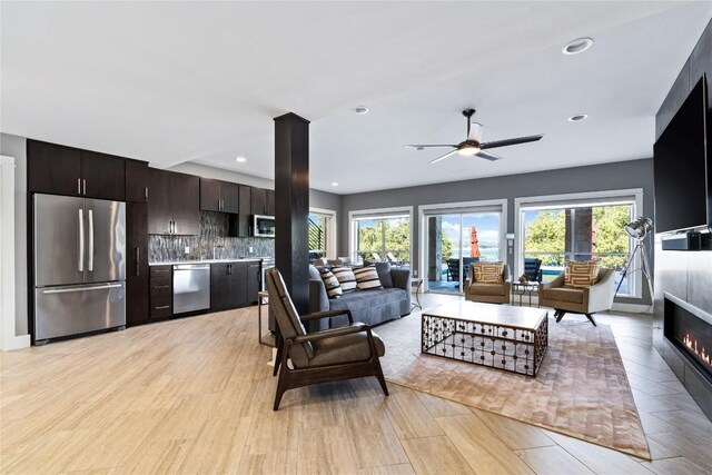15210 Rainbow One St, Austin, TX 78734 - living room featuring healthy amount of natural light, ceiling fan, a glass covered fireplace, light wood-style flooring, and recessed lighting