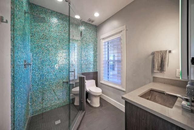 bathroom featuring a shower stall, baseboards, vanity, and toilet