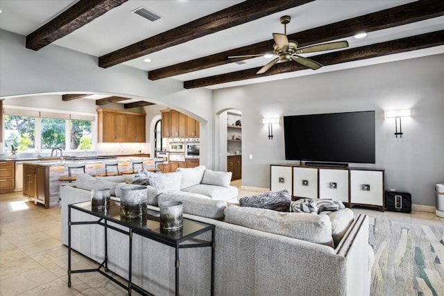 15210 Rainbow One St, Austin, TX 78734 - living room with arched walkways, a ceiling fan, beam ceiling, recessed lighting, and light tile patterned floors