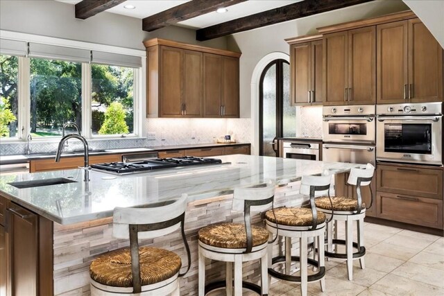 15210 Rainbow One St, Austin, TX 78734 - kitchen with stainless steel gas cooktop, backsplash, beamed ceiling, a sink, and light stone countertops