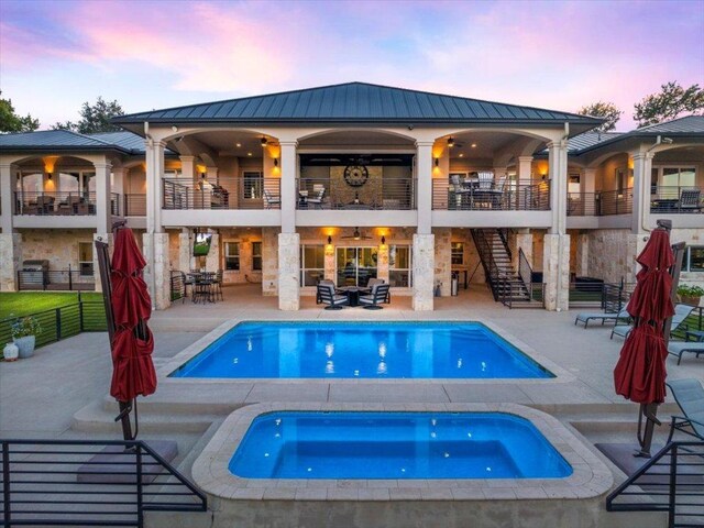 15210 Rainbow One St, Austin, TX 78734 - pool at dusk with an in-ground hot tub, stairs, a patio, fence, and an outdoor pool